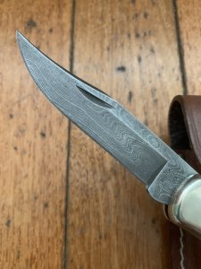 Buck Knife: 1989 Model Buck 110 Classic with Aged Stag Handle and Damascus Blade and Leather Pouch