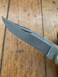 Buck Knife: 1989 Model Buck 110 Classic with Aged Stag Handle and Damascus Blade and Leather Pouch