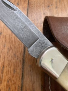 Buck Knife: 1989 Model Buck 110 Classic with Aged Stag Handle and Damascus Blade and Leather Pouch