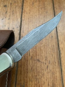 Buck Knife: 1989 Model Buck 110 Classic with Aged Stag Handle and Damascus Blade and Leather Pouch